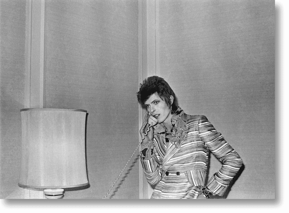 David Bowie aka Ziggy Stardust on the phone next to a lamp